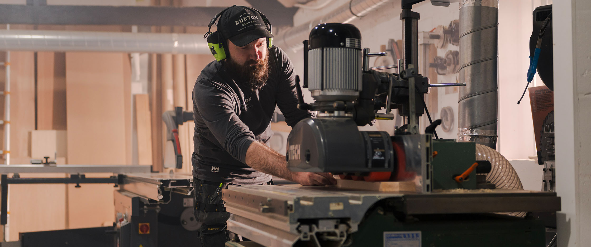 A joiner cutting wood in a workshop